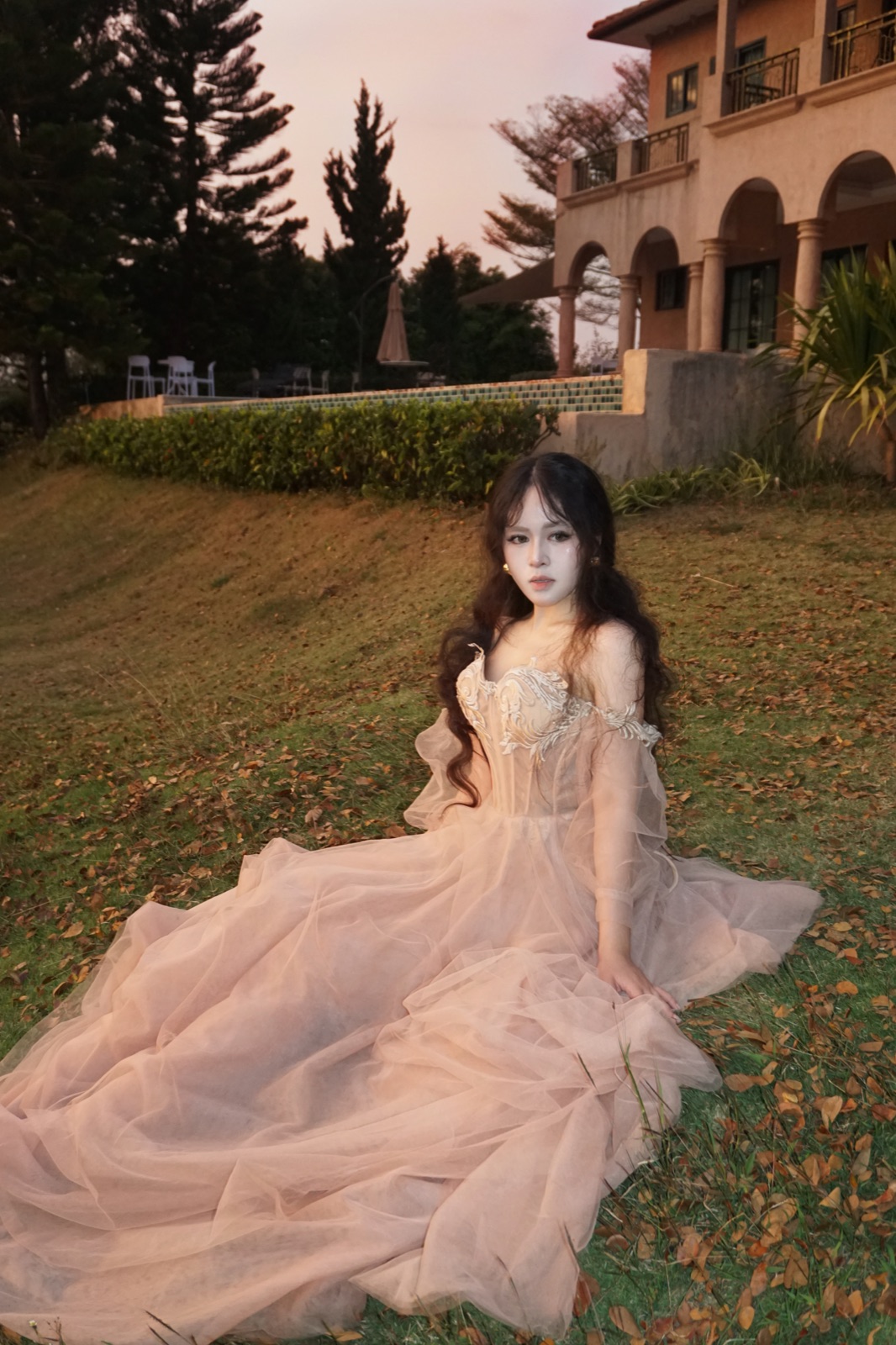 Clara in a flowing evening gown at a resort